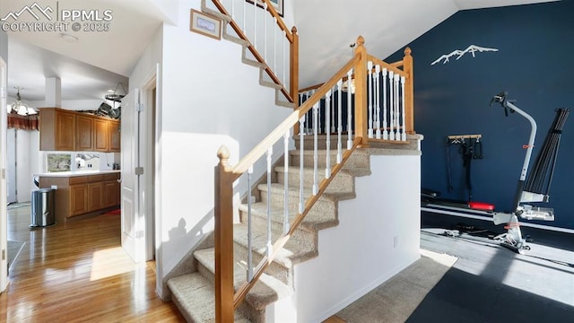 staircase featuring lofted ceiling and hardwood / wood-style flooring