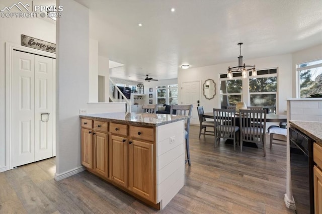 kitchen featuring decorative light fixtures, light stone countertops, ceiling fan, and hardwood / wood-style flooring