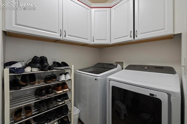 clothes washing area with cabinets and washing machine and clothes dryer