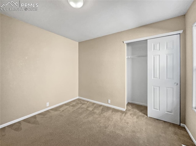 unfurnished bedroom featuring light carpet and a closet