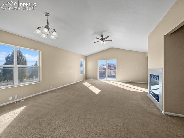 unfurnished living room featuring lofted ceiling, ceiling fan with notable chandelier, and carpet