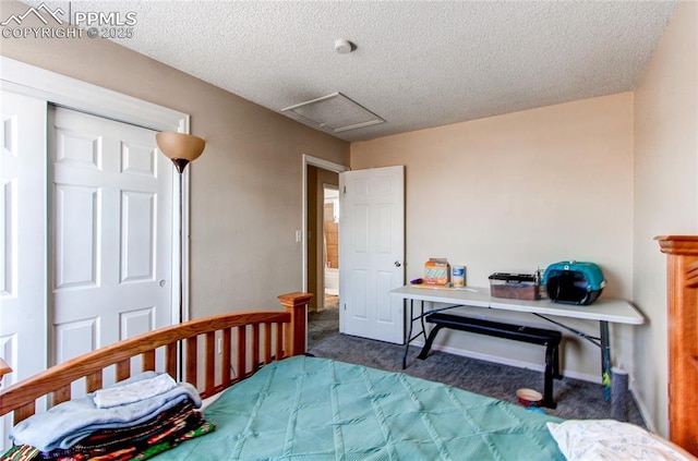 bedroom with a textured ceiling and dark colored carpet