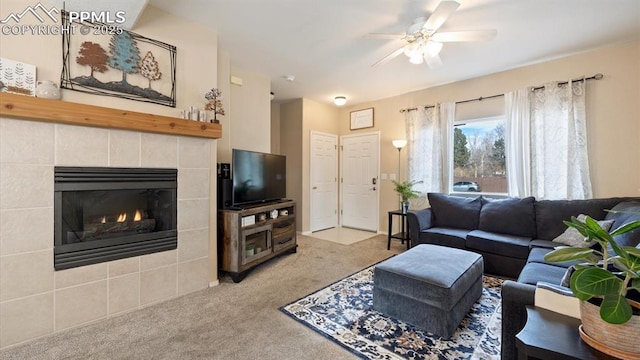 carpeted living room with a fireplace and ceiling fan