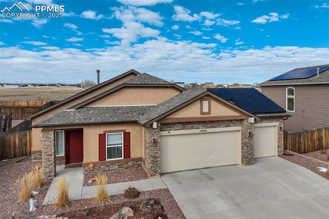 view of front facade with a garage and solar panels