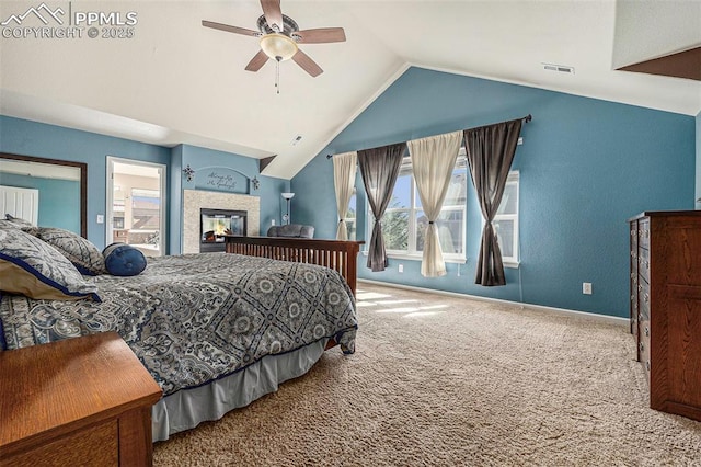 bedroom featuring vaulted ceiling, a tile fireplace, ceiling fan, and carpet