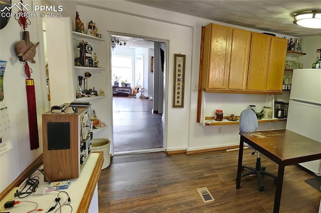 kitchen featuring dark hardwood / wood-style flooring and white fridge