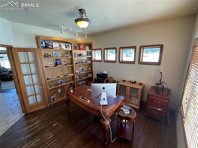 office area with dark wood-type flooring and rail lighting