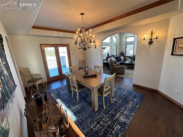 dining space featuring french doors, a healthy amount of sunlight, dark hardwood / wood-style floors, and a raised ceiling