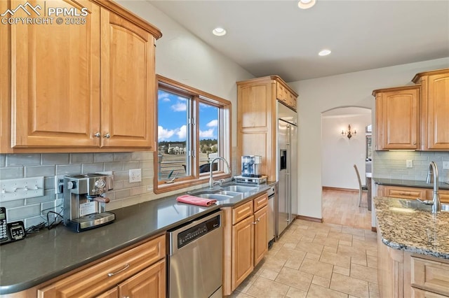 kitchen with stainless steel appliances, sink, and backsplash