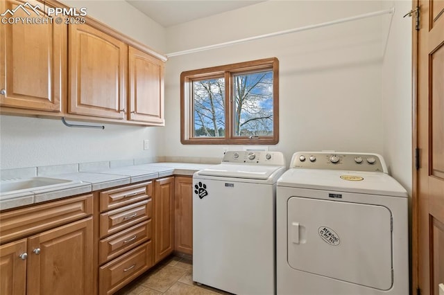 clothes washing area featuring washing machine and dryer and cabinets