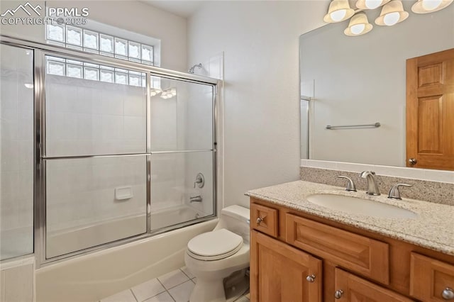 full bathroom featuring tile patterned floors, toilet, combined bath / shower with glass door, and vanity