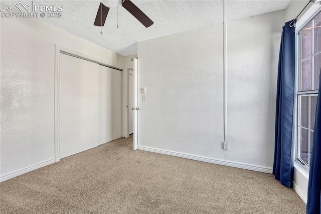 unfurnished bedroom with ceiling fan, carpet flooring, a closet, and a textured ceiling