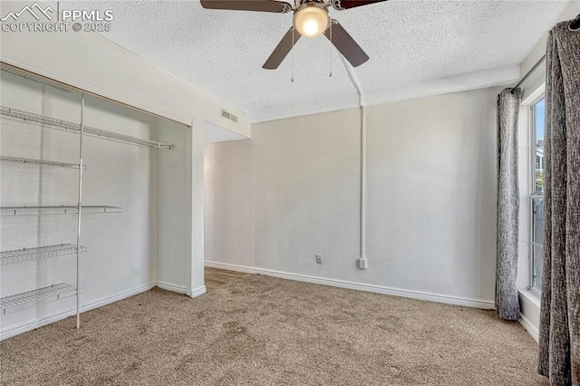 unfurnished bedroom featuring ceiling fan, carpet floors, a closet, and a textured ceiling