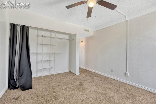 unfurnished bedroom featuring carpet floors, a textured ceiling, ceiling fan, and a closet