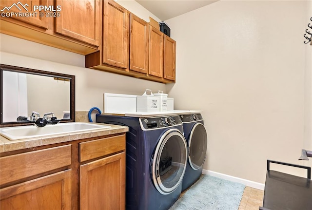 laundry area with cabinets, washer and clothes dryer, sink, and light tile patterned floors