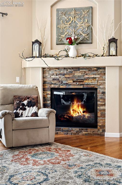 living area with hardwood / wood-style flooring and a fireplace