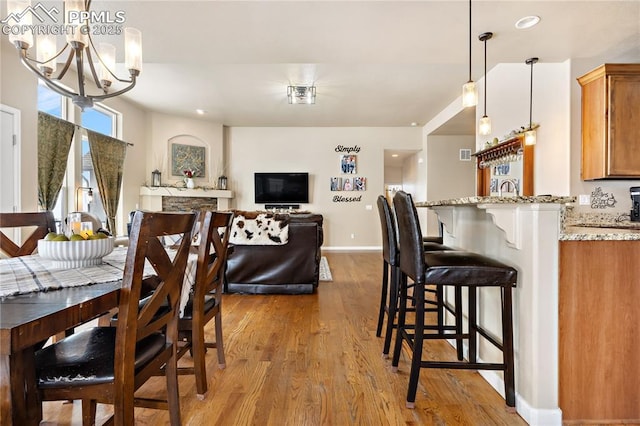 dining space with a chandelier and light hardwood / wood-style flooring