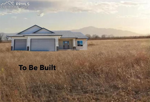 view of front of property featuring a garage and a mountain view