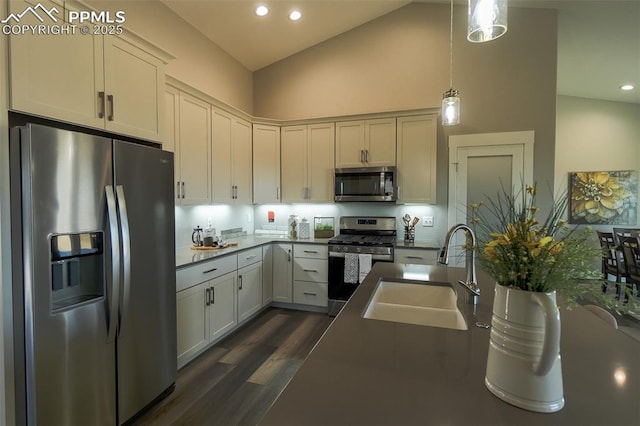 kitchen with sink, white cabinetry, dark hardwood / wood-style floors, pendant lighting, and stainless steel appliances