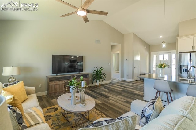 living room with dark wood-type flooring, ceiling fan, high vaulted ceiling, and sink