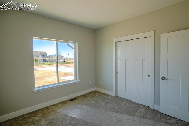 unfurnished bedroom with carpet floors and a closet