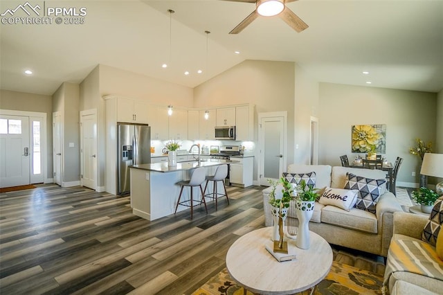 living room with ceiling fan, high vaulted ceiling, sink, and dark hardwood / wood-style flooring