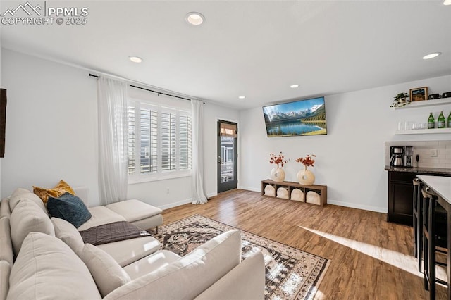 living room featuring bar and light wood-type flooring