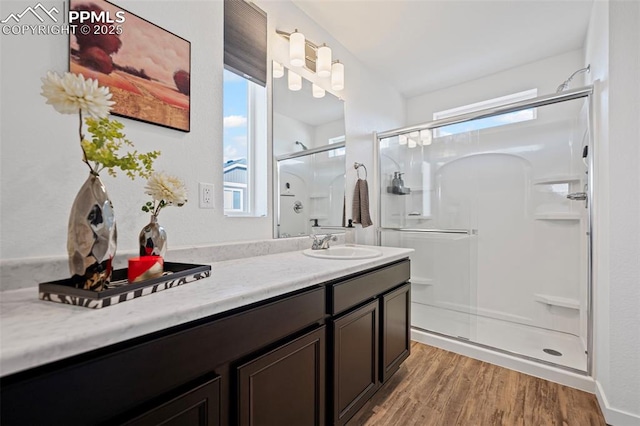 bathroom featuring hardwood / wood-style flooring, vanity, and a shower with door