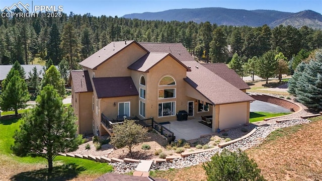 rear view of property featuring a patio and a mountain view