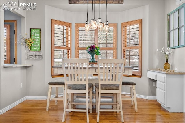 dining space featuring a healthy amount of sunlight, a chandelier, and light hardwood / wood-style flooring