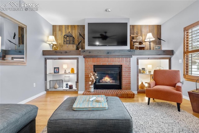 living room with wood-type flooring and a brick fireplace