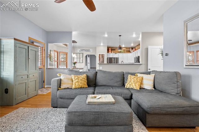 living room featuring light hardwood / wood-style flooring and ceiling fan