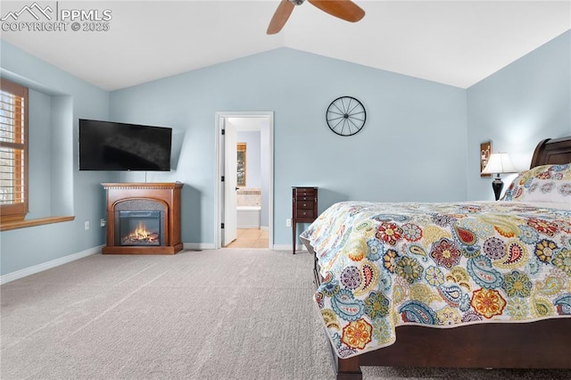 bedroom featuring light carpet, ensuite bath, vaulted ceiling, and ceiling fan