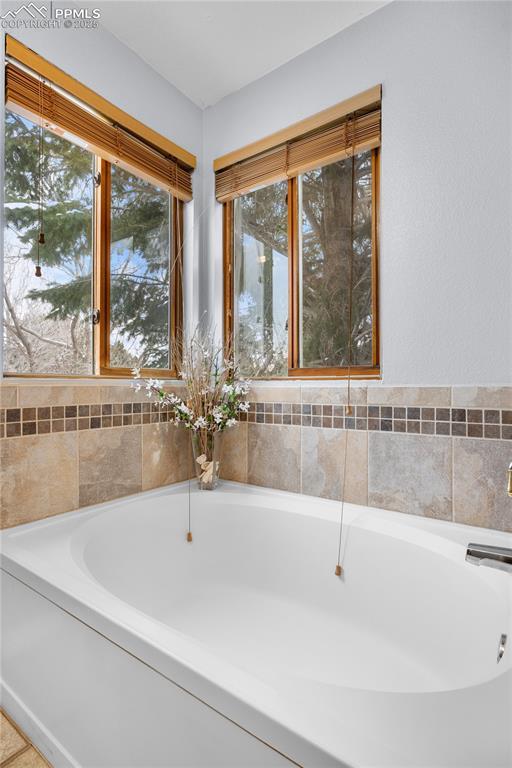 bathroom with tile patterned floors and a tub