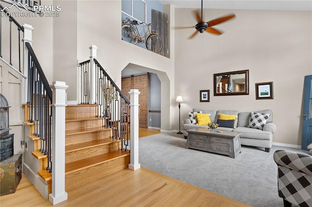 living room featuring hardwood / wood-style flooring, high vaulted ceiling, and ceiling fan