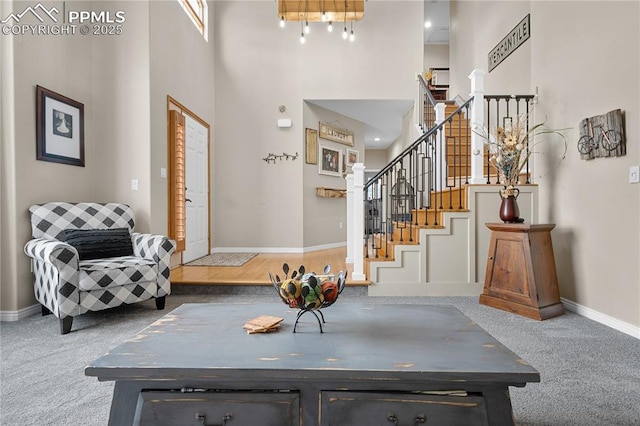 entryway with a towering ceiling and carpet floors