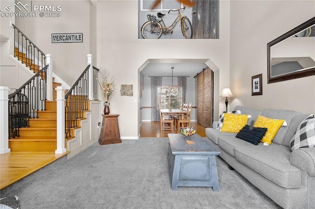 carpeted living room featuring a towering ceiling