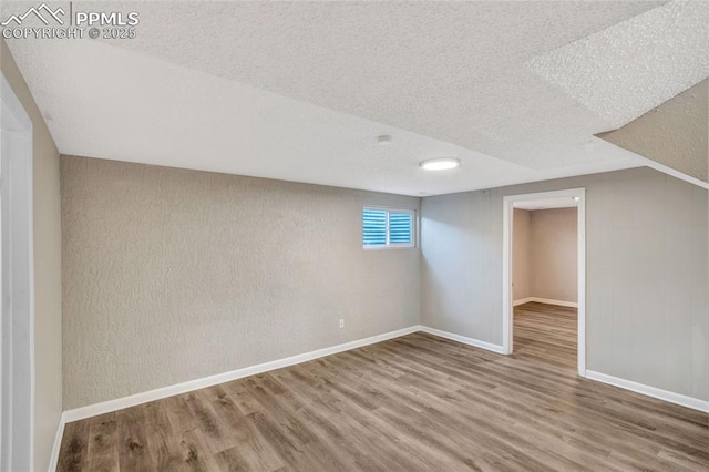 basement with hardwood / wood-style flooring and a textured ceiling