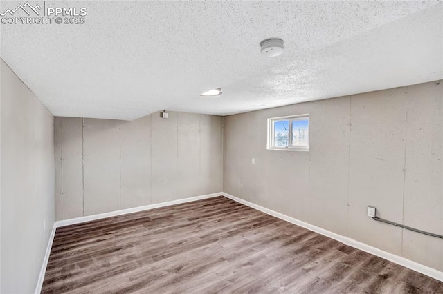 basement with wood-type flooring and a textured ceiling