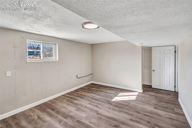 basement featuring hardwood / wood-style floors and a textured ceiling