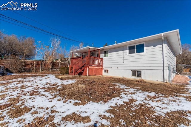 snow covered rear of property featuring a wooden deck