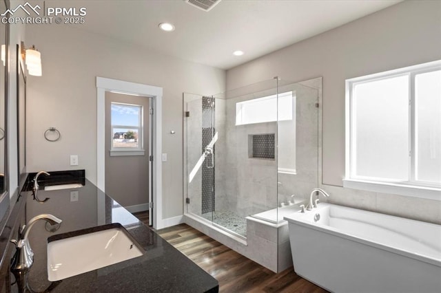 bathroom with wood-type flooring, separate shower and tub, and vanity