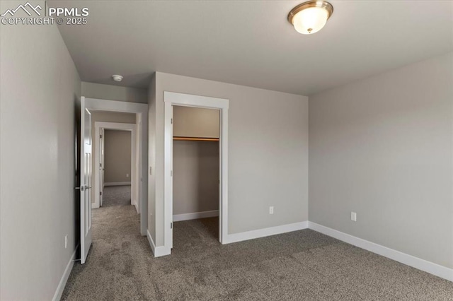 unfurnished bedroom featuring a walk in closet, carpet flooring, and a closet