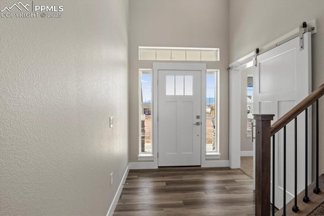 entrance foyer featuring a barn door and dark hardwood / wood-style flooring