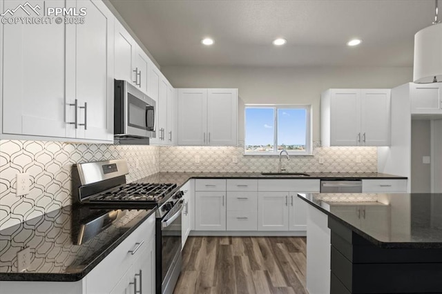 kitchen with dark wood-type flooring, sink, stainless steel appliances, decorative backsplash, and white cabinets