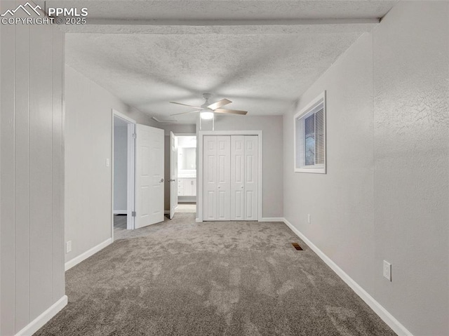 unfurnished bedroom with ceiling fan, carpet floors, a textured ceiling, and a closet