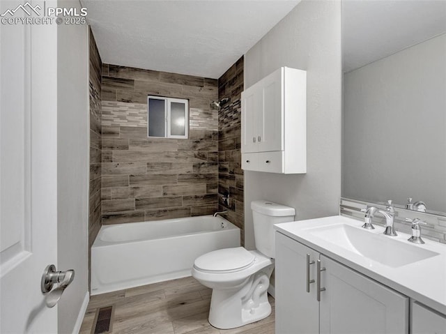 full bathroom with vanity, toilet, hardwood / wood-style floors, and tiled shower / bath