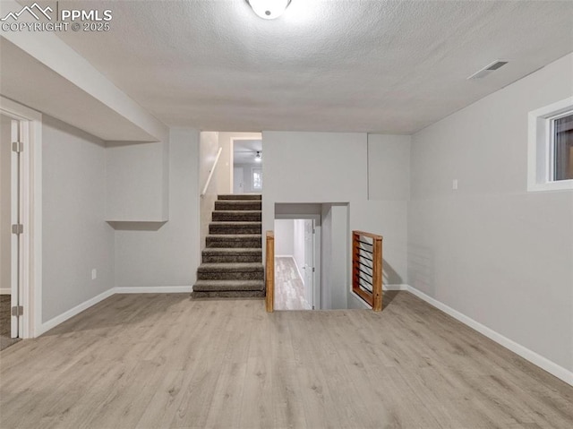 basement with a textured ceiling and light wood-type flooring