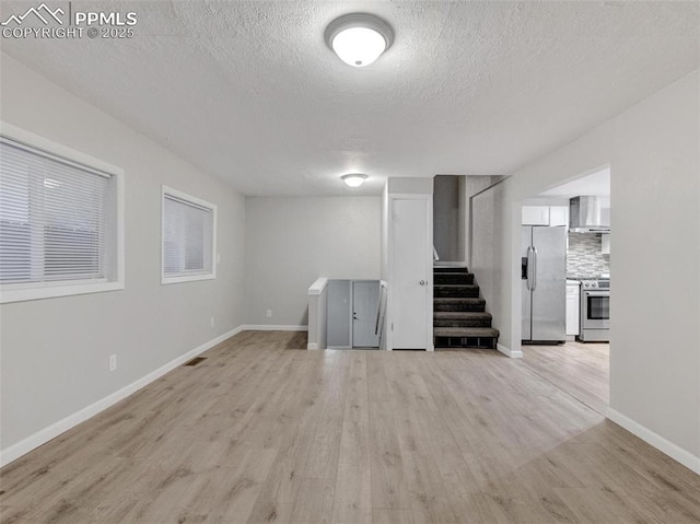 interior space featuring a textured ceiling and light wood-type flooring