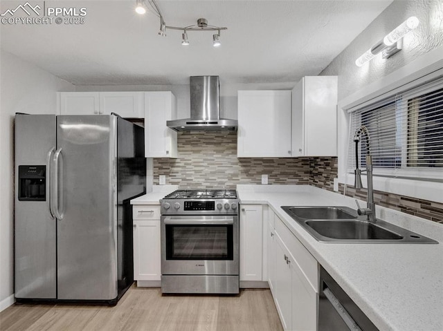 kitchen with white cabinetry, appliances with stainless steel finishes, wall chimney exhaust hood, and sink